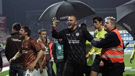 Florian Bruns (Pauli) und Torwart Benedikt Pliquett (Pauli) begleiten Schiedsrichter Deniz Aytekin vom Spielfeld nach Spielabruch und wüten über das Verhalten der Anhänger