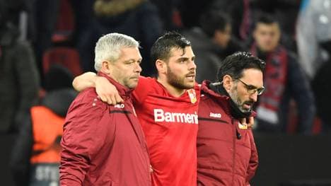 Kevin Volland (M.) wird von zwei Betreuern vom Feld begleitet