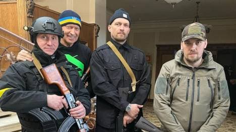 Oleksandr Usyk (2.v.r.) mit einem Sturmgewehr in der Hand