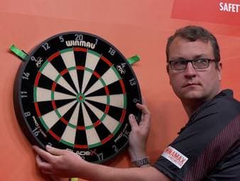 Beim European Darts Grand Prix kommt es vor dem Achtelfinale zwischen Gerwyn Price und Chris Dobey zu einer kuriosen Szene. Hängt etwa das Dartboard schief?