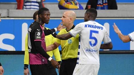 Osnabrücks Aaron Opoku (L) mit Schiedsrichter Nicolas Winter und Leroy Kwadwo (MSV Duisburg)