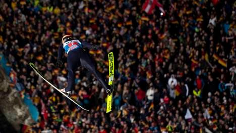 Karl Geiger schwebt über dem schwarz-rot-goldenen Fahnenmeer von Oberstdorf