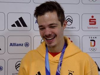 Philipp Raimund spricht über seinen Olympiasieg im Skispringen und erklärt scherzhaft, warum es auf der Schanze besser klappt als beim Fußball.