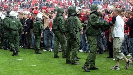 Polizisten trennen die Fans aus Lautern vor den Anhängern aus Köln, nachdem es auf dem Spielfeld zu Ausschreitungen gekommen war 