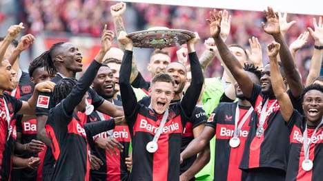 Florian Wirtz hebt die Meisterschale falsch herum in die Höhe