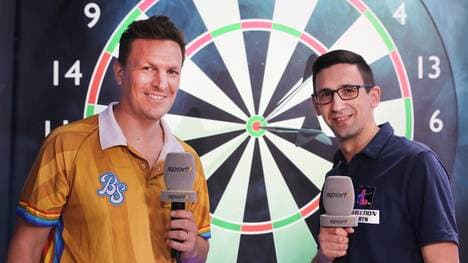 Robert Marijanovic (r,) kommentiert bei SPORT1 die Darts-WM mit Basti Schwele