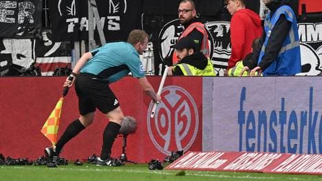 Beim Bundesliga-Spiel zwischen Mainz und Frankfurt wird Linienrichter Robert Wessel mit einer Stange beworfen