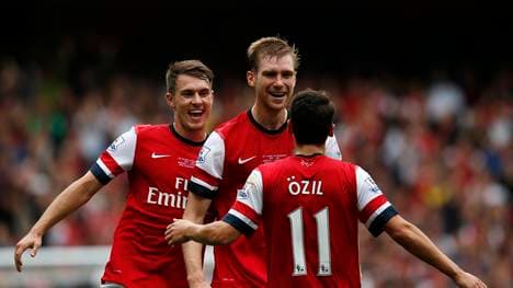 Aaron Ramsey (l.) und Mesut Özil (v.) feiern ein Tor von Per Mertesacker