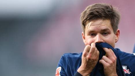 Dominik Kaiser von RB Leipzig hält sich das Trikot vor das Gesicht