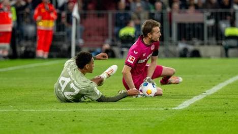 Leverkusens Keeper Lukas Hradecky (r.) ist am Ball, Jamal Musiala vom FC Bayern hat das Nachsehen.