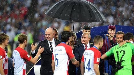 FRusslands Präsident Wladimir Putin bleibt bei der Siegerehrung als einziger trockenrance v Croatia - 2018 FIFA World Cup Russia Final