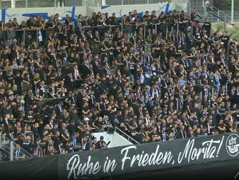 Emotionale Szenen vor dem Anpfiff: Mit einer Kranzübergabe wird zunächst eines verstorbenen Fans gedacht.