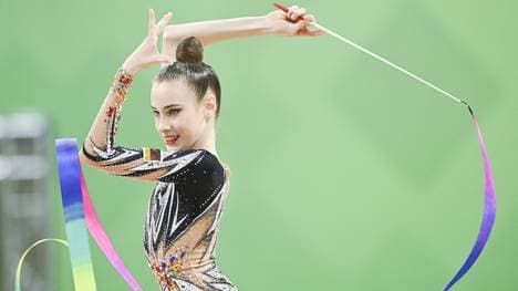 Darja Varfolomeev steht mit Ball und Reifen im Finale