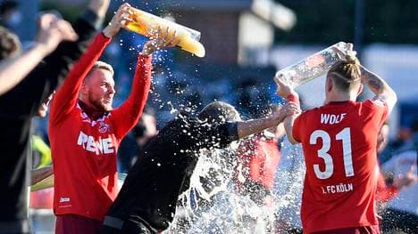 Friedhelm Funkel (M.) bekommt von Jannes Horn und Marius Wolf eine Bierdusche verpasst