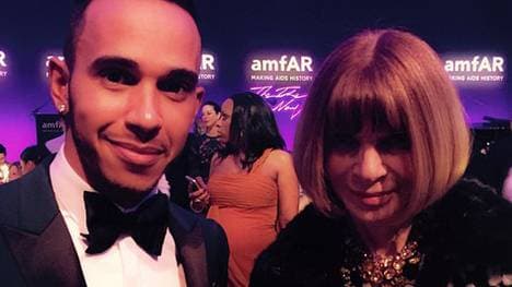 Lewis Hamilton und Anna Wintour posieren lächelnd für ein gemeinsames Foto. 