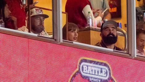 NFL-Star Travis Kelce, Taylor Swift and Jason Kelce (v.l.) verfolgen ein College-Football-Spiel