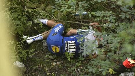 Remco Evenepoel wartet nach dem Sturz von der Brücke auf Rettung
