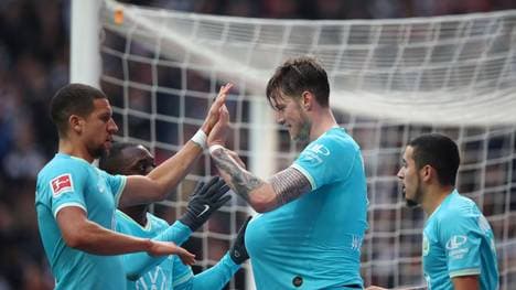 FRANKFURT AM MAIN, GERMANY - NOVEMBER 23: Wout Weghorst of VfL Wolfsburg celebrates with teammates after scoring his team's first goal  during the Bundesliga match between Eintracht Frankfurt and VfL Wolfsburg at Commerzbank-Arena on November 23, 2019 in Frankfurt am Main, Germany. (Photo by Christian Kaspar-Bartke/Bongarts/Getty Images)