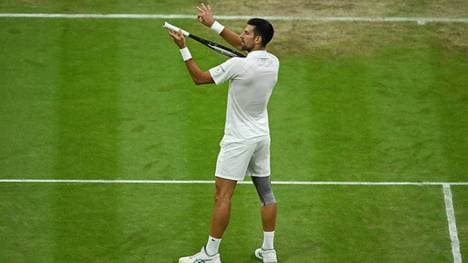 Novak Djokovic tut so, als würde er auf seinem Schläger Geige spielen