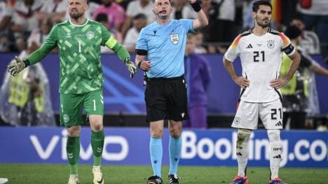 Schiedsrichter Michael Oliver zeigt Richtung Stadiondach