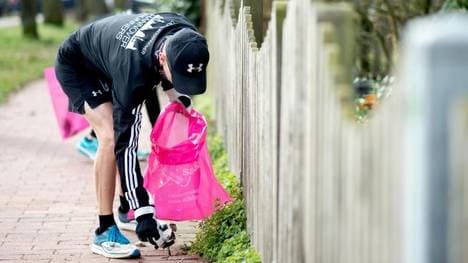Ein Jogger sammelt Müll