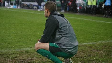 Patrick Herrmann hockt nach dem Abpfiff fassungslos auf dem Rasen in Saarbrücken