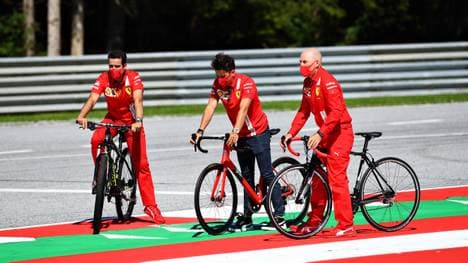 Charles Leclerc (M.) fährt vor dem Saisonstart die Strecke in Spielberg mit dem Rennrad ab
