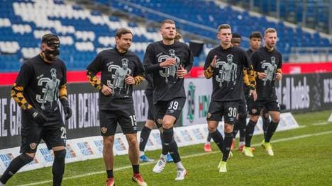 Die Dresdner Spieler wärmen sich auf mit T-Shirts in Gedenken an die verstorbene Vereinslegende Hans-Jürgen Dixie Dörner