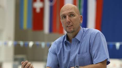 Ex-Schwimm-Bundestrainer Dirk Lange sitzt vor dem Schwimmbecken