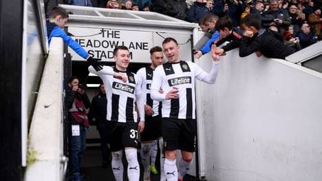 Kristian Dennis (l.) und Callum Roberts von Notts County klatschen mit den Fans ab