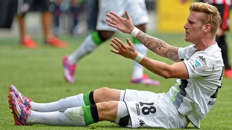Andre Hahn von Borussia Mönchengladbach sitzt auf dem Rasen und ärgert sich