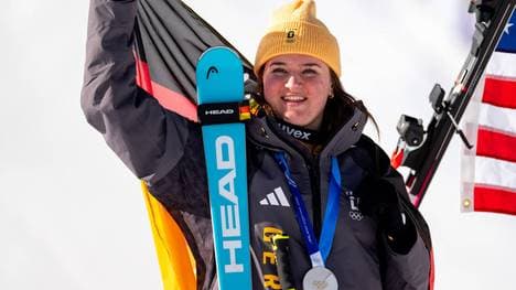 Emma Aicher freut sich bei der Siegerehrung auf dem Podium über die gewonnene Silbermedaille