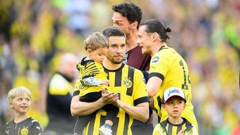 Raphael Guerreiro mit seinem Kind auf dem Arm nach dem letzten Bundesliga-Spiel gegen die Hertha