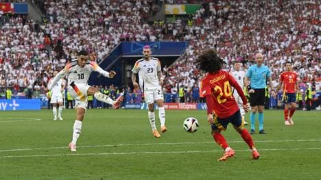 Jamal Musiala trifft mit einem Schuss Marc Cucurella (Spanien) an der Hand