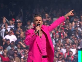 Beim Rugby AFL Grand Final sorgt ein Star-Gast für gute Stimmung. Der komplett in rosa gekleidete Robbie Williams heizt mit einem Medley der Rugby-Meute an.