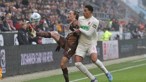St. Paulis Jackson Irvine im Zweikampf mit Augsburgs Noahkai Banks 