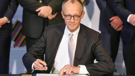 Merz bei der Unterzeichnung