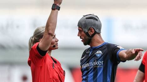 Bibiana Steinhaus (l.) zeigt Paderborns Klaus Gjasula seine 14. Gelbe Karte der Saison