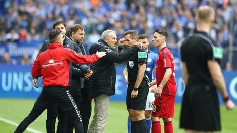 Freiburgs Trainer Christian Streich (mitte) reagiert erbost auf den Platzverweis von Petersen