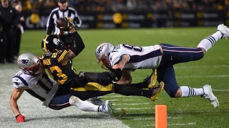 Joe Haden (m.) fängt einen Ball, der eigentlich für Julian Edelman (l.) gedacht war