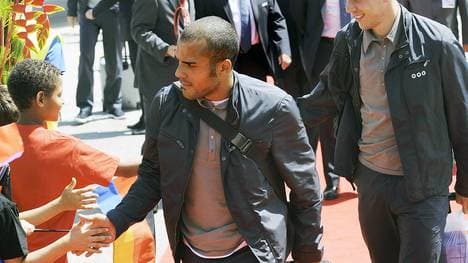 David Odonkor klatscht mit Fans ab und zieht dabei einen Koffer