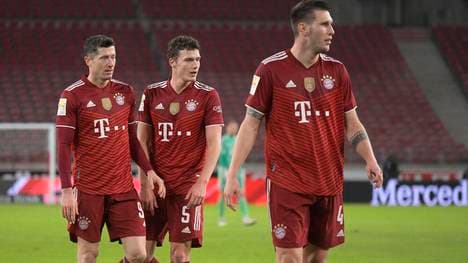 Benjamin Pavard (M.) fühlt mit Robert Lewandowski (l.)