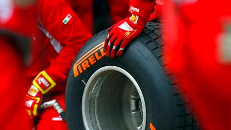 Ferrari technicians handle a Pirelli wet