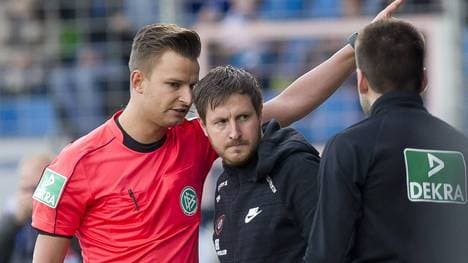 Aue-Trainer Hannes Drews (M.) musste nach einem Flaschenwurf auf die Tribüne