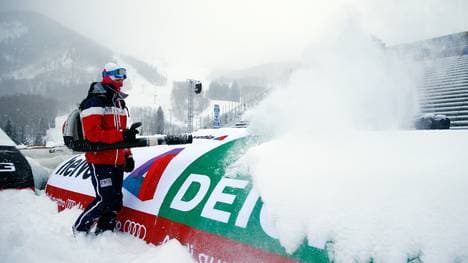 Ein Arbeiter versucht, die Zieleinfahrt vom Schnee zu befreien