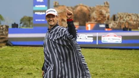 Ogier mit einem Poncho bei der Siegerehrung