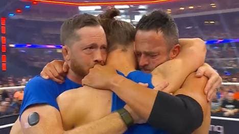 Kyle O'Reilly (l.) und Roderick Strong umarmen den verletzten Adam Cole