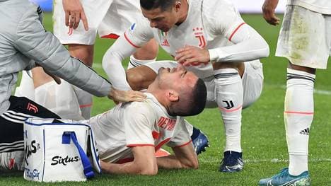 Juventus' Portuguese forward Cristiano Ronaldo (C) tend to Juventus' Turkish defender Merih Demiral after he was injured during the Italian Serie A football match AS Roma vs Juventus on January 12, 2020 at the Olympic stadium in Rome. (Photo by Tiziana FABI / AFP) (Photo by TIZIANA FABI/AFP via Getty Images)