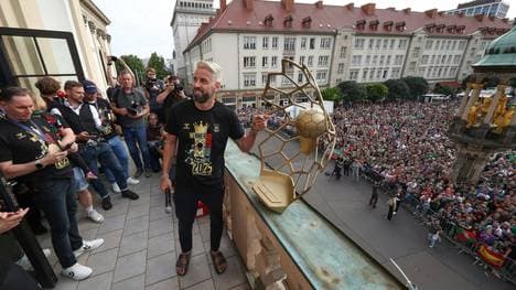 Wiegert reckt beim Emfang den Pokal in die Höhe.