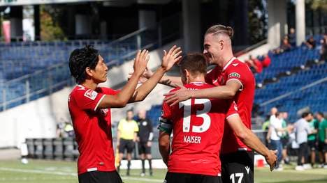 Hannovers Genki Haraguchi (l.), und Marvin Ducksch (r.) feiern mit Torschütze Dominik Kaiser 